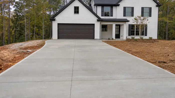 concrete installation completed by a local contractor at a painted-white-brick two-story home in Lawrenceville, GA, under an overcast sky.