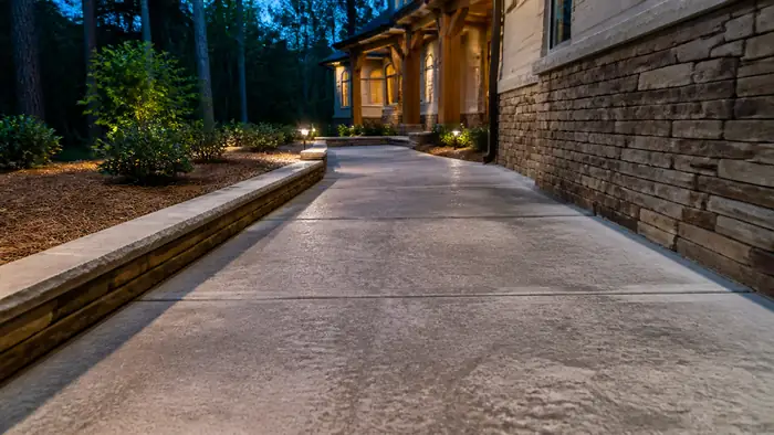 concrete sidewalk installation completed by a local contractor at a stacked-stone and stucco home in Lawrenceville, GA, at blue hour.