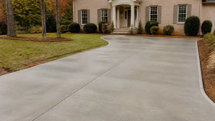 concrete slab installation completed by a local contractor at a tan-brick colonial in Lawrenceville, GA, under bright midday cloud.