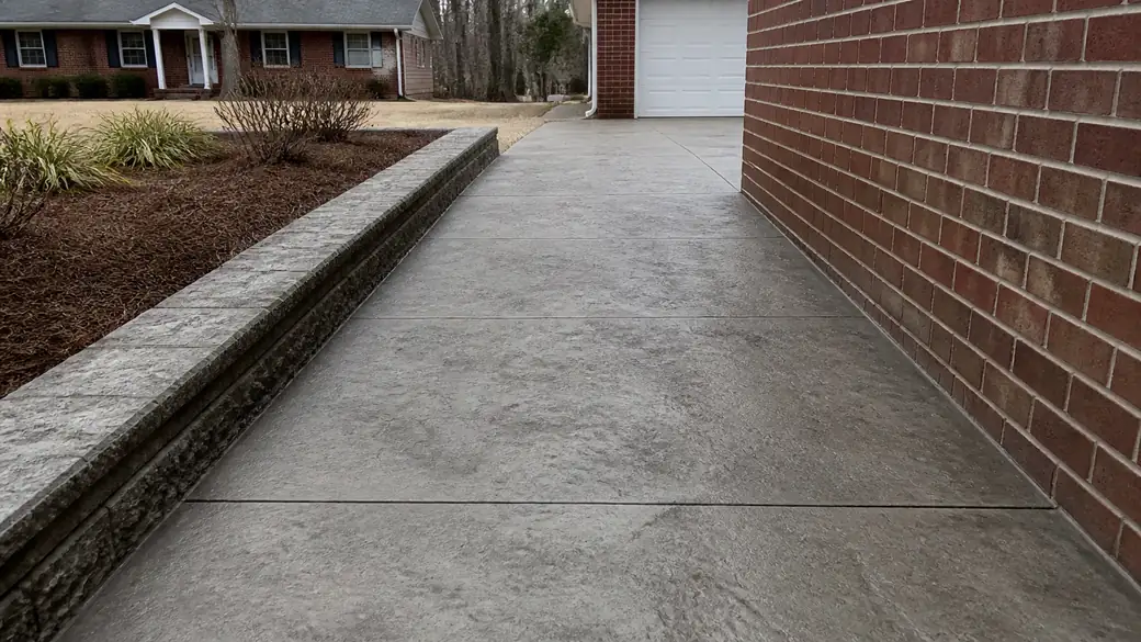 stamped concrete installation completed by a local contractor at a red-brick ranch home in Lawrenceville, GA, under an overcast sky.