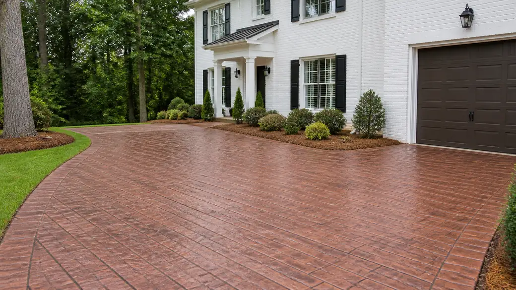 Stamped concrete patio in a running-bond brick pattern at a painted-white-brick two-story home in Lawrenceville, GA, under bright midday cloud.